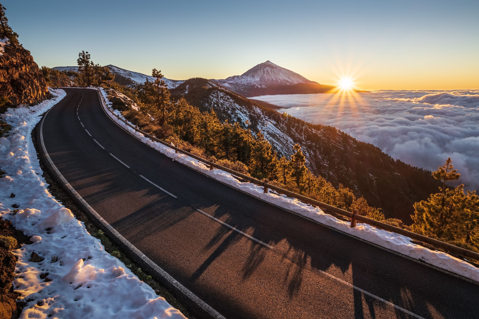 Beautiful view of the road surrounded by snow volcano on the Teide volcano background